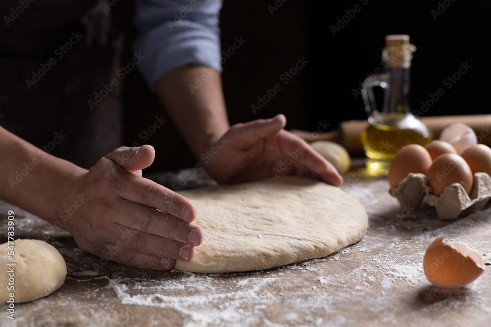 Obraz premium Chef man kneading dough bread or pizza for homemade cooking at table