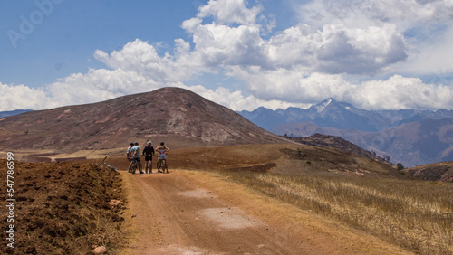 Dry andean landscape with dirt road with bikers at the end near mountains Cusco, Peru