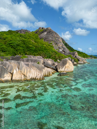Drone view of Anse Source d'Argent beach, La Digue Island, Seyshelles' Drone view of Tropical Sunny beach and coconut palms on Seychelles. Summer vacation and tropical beach concept.