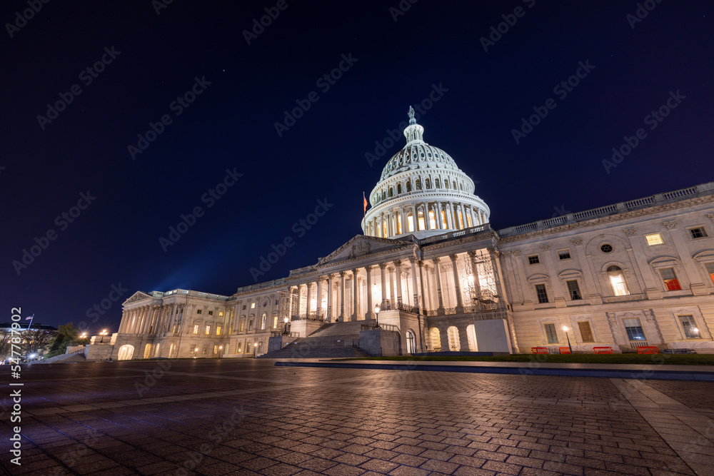 The east side of the United States Capitol Building in Washington, DC on a late autumn night. Spotlights illuminate the Capitol Dome and Statue of Freedom. No people are seen..