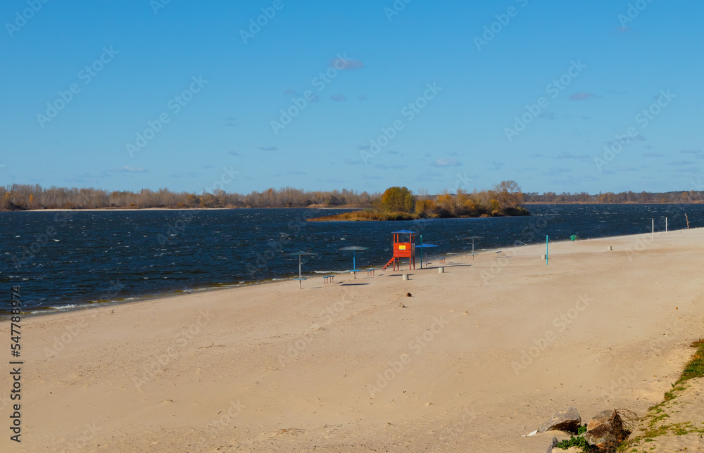 Obraz premium Empty sandy beach on the banks of the Dnieper river on a sunny autumn day. Kremenchuk City, Ukraine