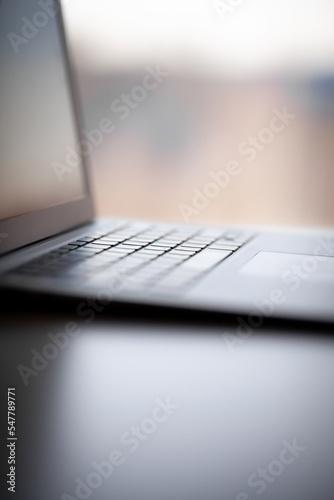 Close-up of the keyboard of an open laptop ready to work on the table. Side view, selective focus on the keyboard. The concept of computer security and work on the Internet.