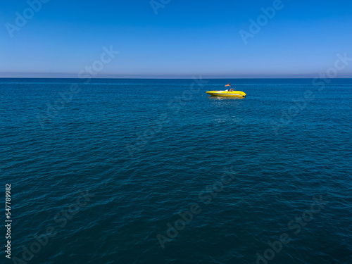 Fototapeta Naklejka Na Ścianę i Meble -  Yellow motor boat all alone on the blue sea