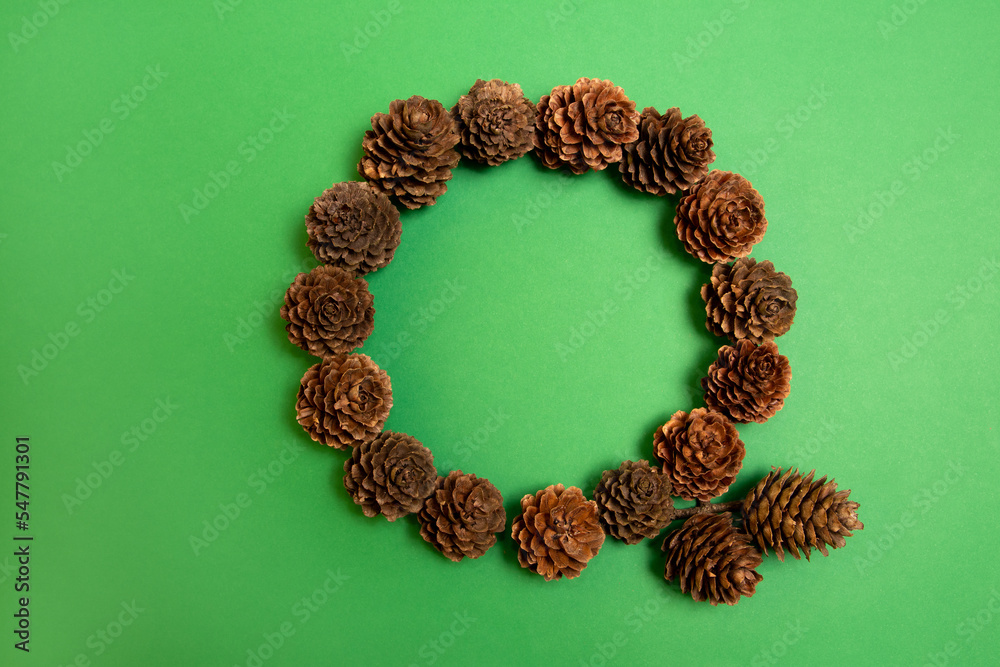 Christmas pine cones wreath on a green background. Flat lay circle frame. Christmas pine cones wreath on a green background. Flat lay circle frame.