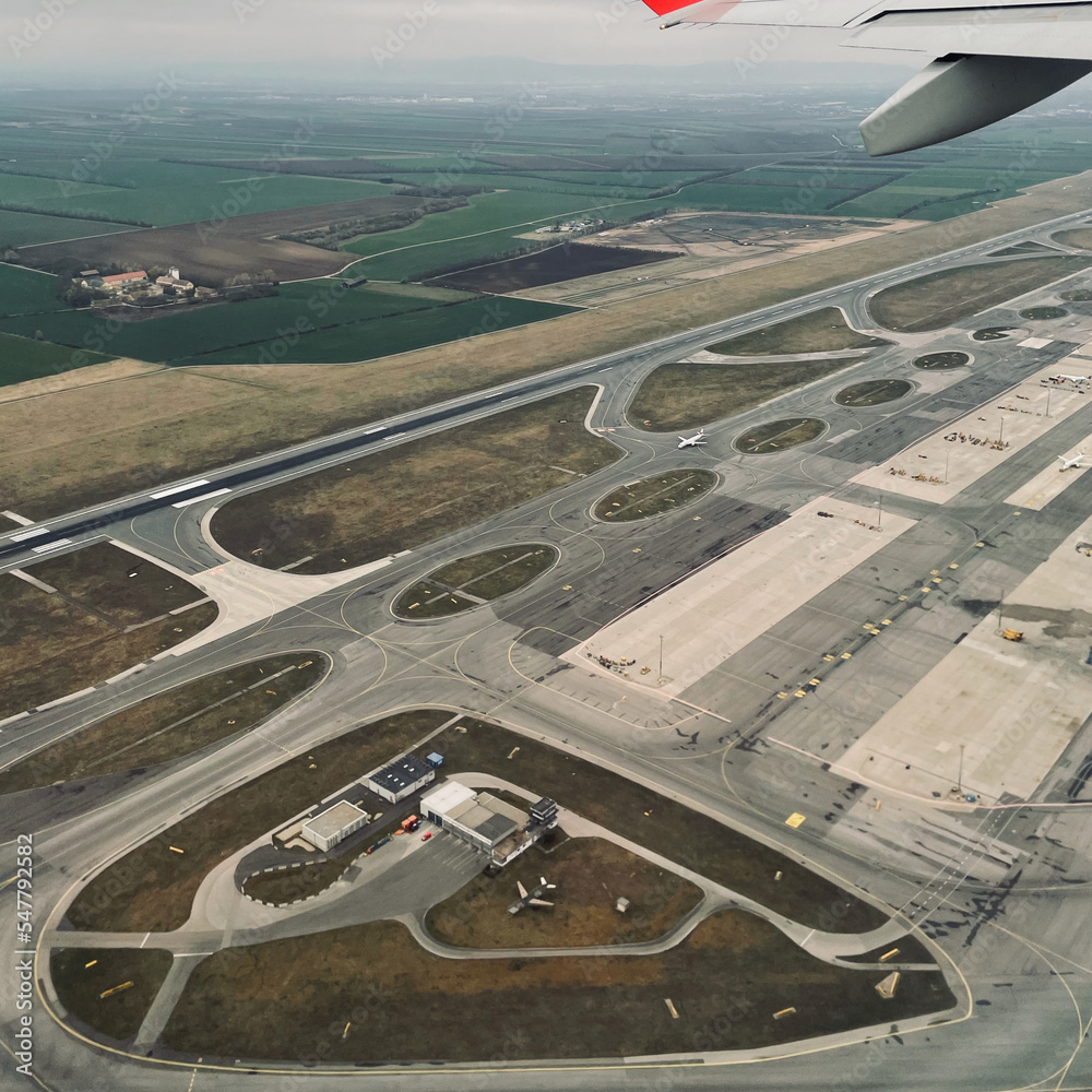 Przelot samolotu nad pasem startowym lotniska - obrazy, fototapety, plakaty 