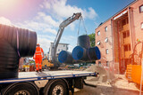 Attenuation tank made of big diameter plastic pipe delivered on construction site by truck and offloaded with excavator
