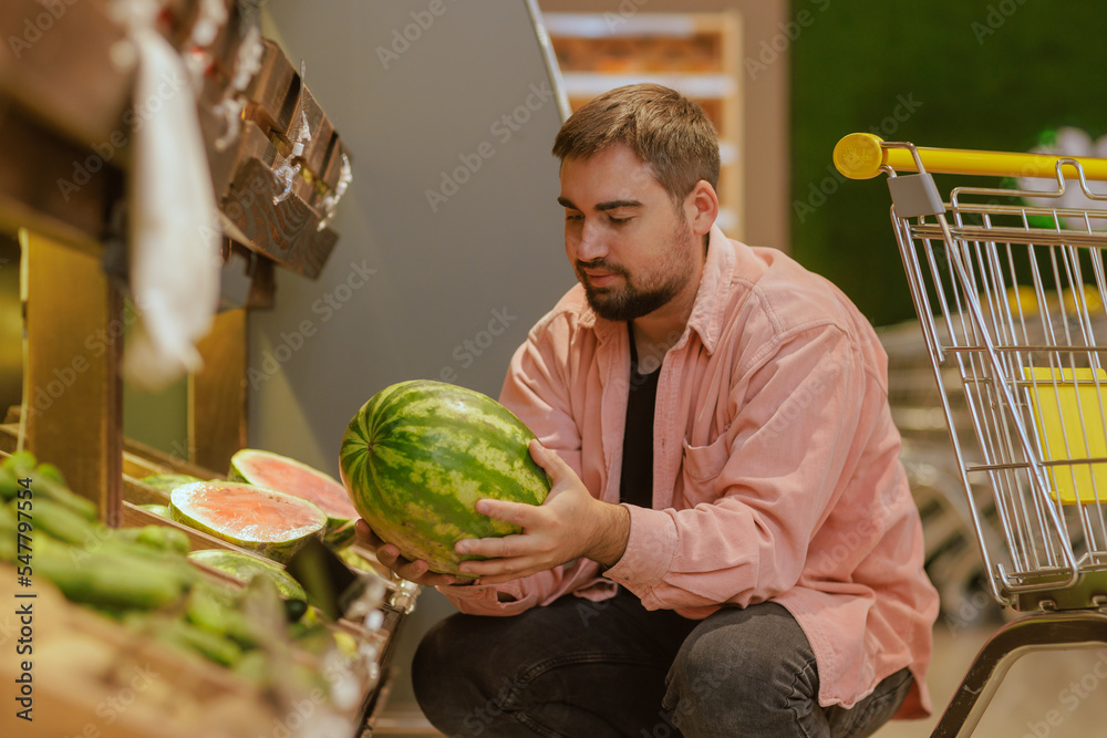 Fototapeta premium the guy makes purchases in the supermarket, the concept of shopping