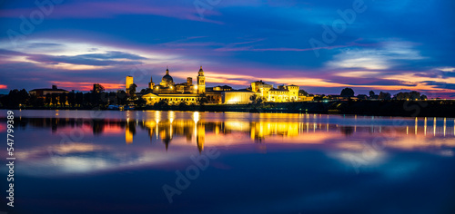 Panoramic evening view of Mantua, Lombardy, Italy; scenic twilight skyline view of the medieval town reflected in the lake waters photo