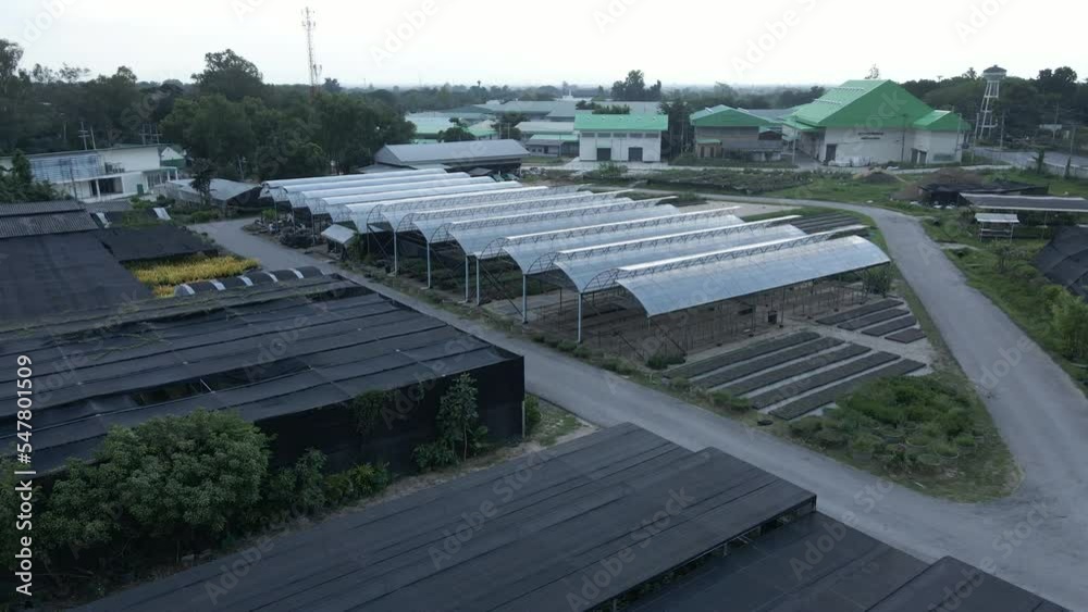Birds eye view of a greenhouse with houses in the background and asphalted roads Birds eye view of a greenhouse with houses in the background and asphalted roads