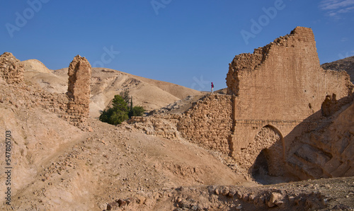 Female posing on the remains of aqueduct from the Roman period carrying water to the wadi Qelt valley in Judean Desert near Jericho city. Remains of a beautiful overpass resting on a number of arches. photo