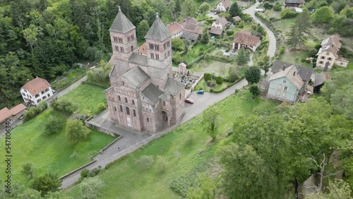 Panoramic aerial drone view of the famous abbey of Murbach and its village in the heart of Florival valley near Guebwiller (Alsace, France), in the middle of the mountain forest, a summer day photo