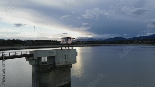 Water intake tower of the Michelbach lake dam (Upper-Rhine, Alsace, France), in drought weather in summer, with a very low water level, at sunset, with the mountains in the background photo