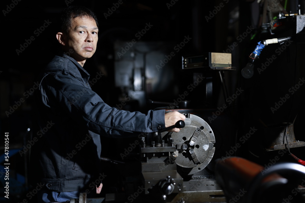 custom made wallpaper toronto digitalA craftsman poses in gray work clothes in front of a lathe at a local factory. Conceptual images of the essence of manufacturing, technical succession, and the challenge of high-precision machining.