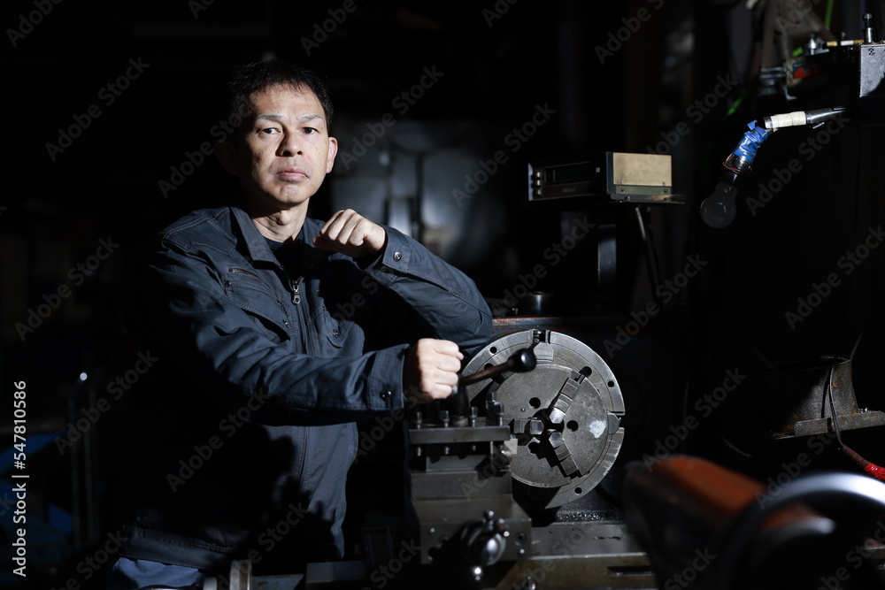 custom made wallpaper toronto digitalA craftsman poses in gray work clothes in front of a lathe at a local factory. Conceptual images of the essence of manufacturing, technical succession, and the challenge of high-precision machining.