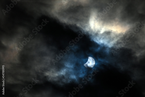 Solar eclipse. Annular eclipse viewed through clouds. Moon in front of the sun. Solar eclipse. Dark, magical and mystical sky.