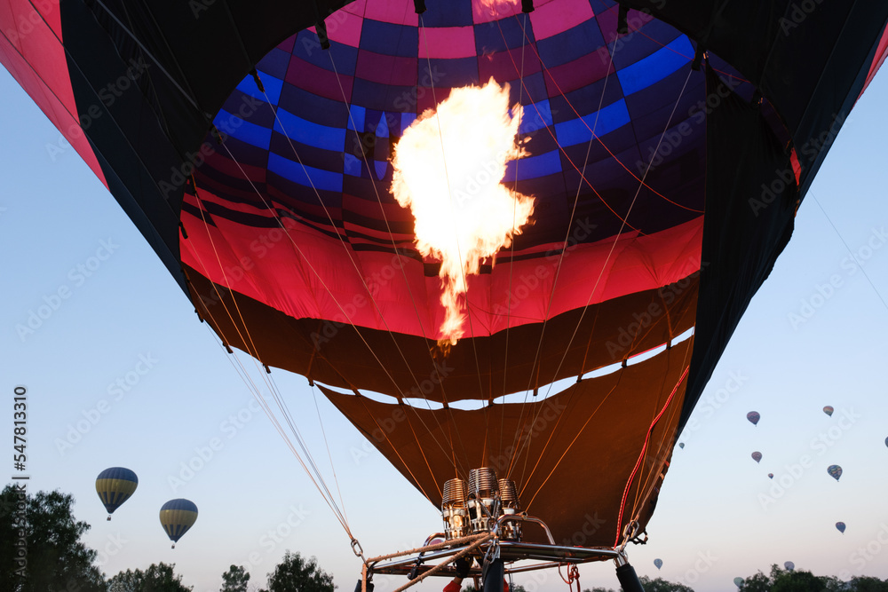 Obraz premium A view inside a hot air balloon with more balloons in the distance