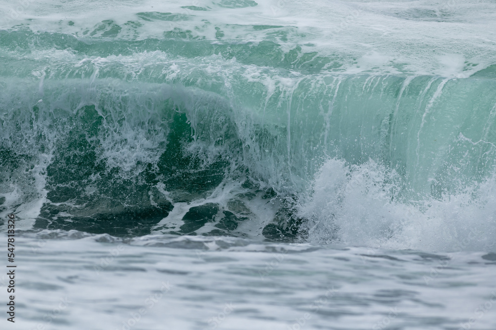 An angry turquoise green color massive rip curl of a wave as it rolls ...