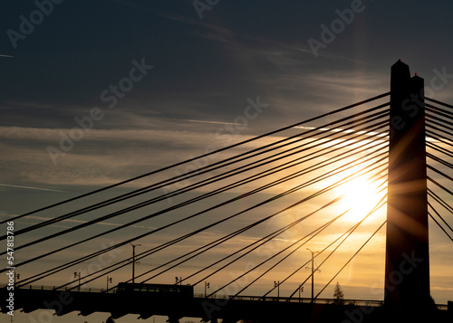 Train going over Tilikum Crossing in Portland, Oregon during sunrise photo