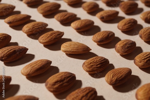 Delicious raw almonds on beige background, closeup