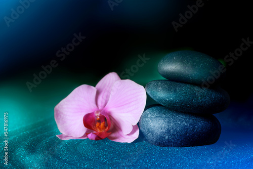 Spa stones and orchid flower on sand with beautiful pattern. Zen concept