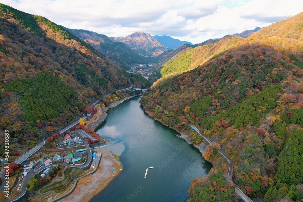 Fototapeta premium 紅葉する山に囲まれた湖と雲