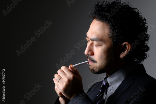 煙草を吸うダンディな男性の横顔　タバコに火をつける photo