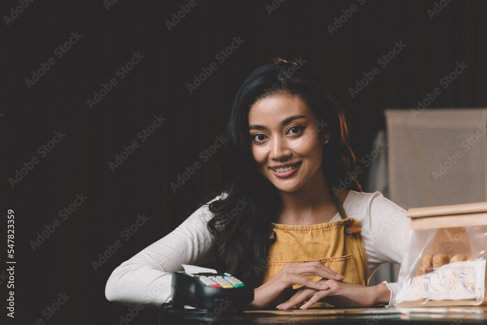 cashier woman smiling at counter service customer for paying with credit card and scanning for payment. woman at her small restaurant business . cashier woman smiling at counter service customer for paying with credit card and scanning for payment. woman at her small restaurant business .