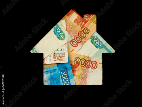 Ruble banknote in shape of house on black background. Concept of Investment property, Mortgage concept. Investment risk and uncertainty in real estate housing market, utility bills. Top view flat lay