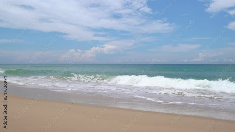 Summer sea background.Blue sky white clouds over ocean waves break on sand beach.Waves crashing against an empty beach.Sea waves and beautiful sand beach in Patong Phuket Thailand. High quality video Summer sea background.Blue sky white clouds over ocean waves break on sand beach.Waves crashing against an empty beach.Sea waves and beautiful sand beach in Patong Phuket Thailand. High quality video