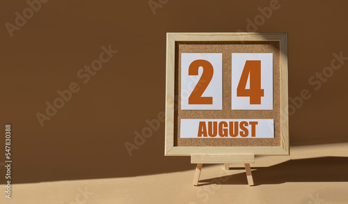 August 24th. Day 24 of month, Calendar date. Cork board, easel in sunlight on desktop. Close-up, brown background.  Summer month, day of year concept photo