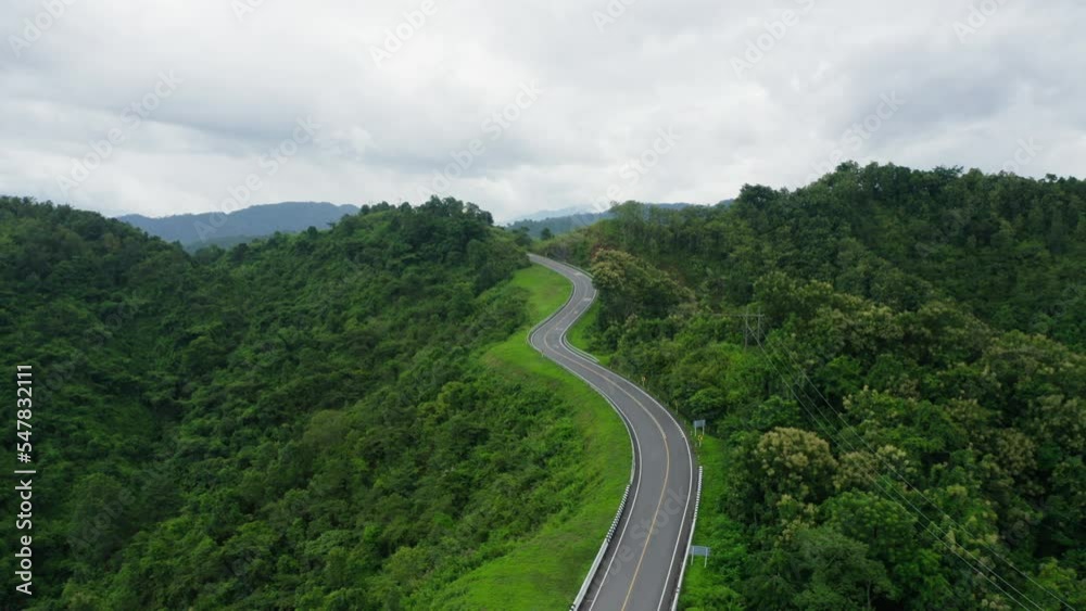 Aerial view drone fly over of winding road in rainy season on tropical rainforest mountain in Nan province, Thailand. footage b roll, Aerial footage of winding and dangerous road. Aerial view drone fly over of winding road in rainy season on tropical rainforest mountain in Nan province, Thailand. footage b roll, Aerial footage of winding and dangerous road.