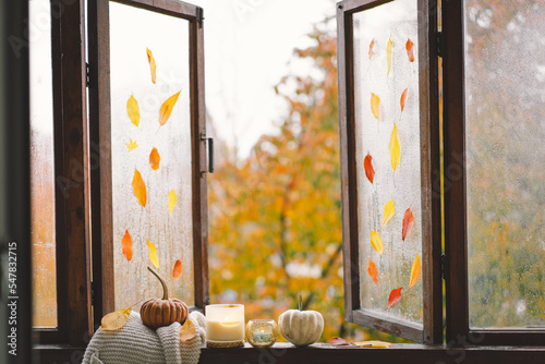 Sweet Home. Still life details in home on a wooden window. Sweater, candle, hot tea and autumn decor. Autumn home decor. Cozy fall mood. Thanksgiving. Halloween. Cozy autumn or winter concept.
