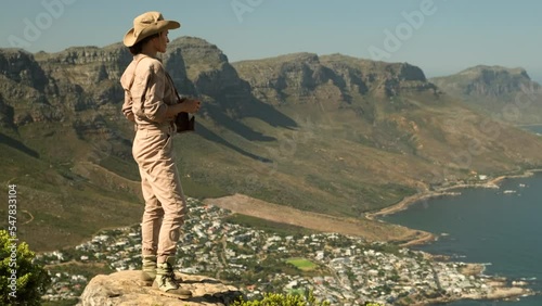 woman tourist takes a photo high in the mountains. Table Mountain and 12 Apostles from Lion's Head. Cape Town. South Africa. Table Mountain and the Twelve Apostles mountain range seen from Lion's Head photo