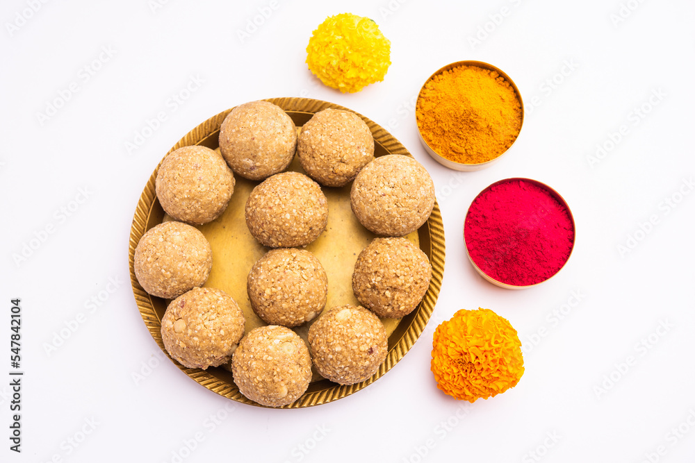 tilgul or til gul laddu or Sesame seed jaggery ball or til ke laddo with flower and haldu kumkum tilgul or til gul laddu or Sesame seed jaggery ball or til ke laddo with flower and haldu kumkum