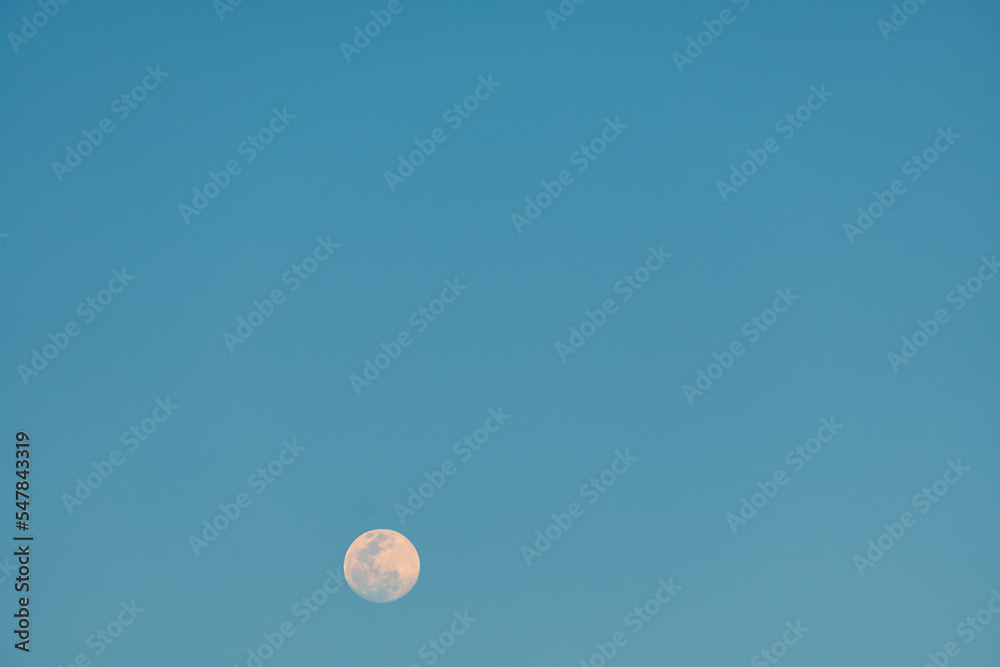 Full moon in the blue sky