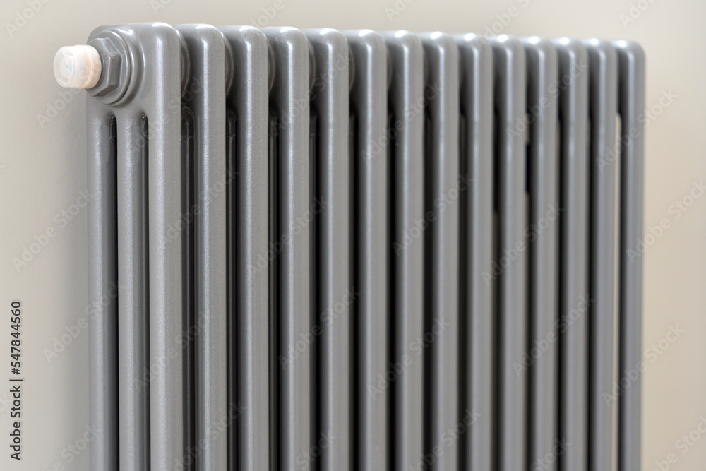 A man's hand holds a heating thermostat knob. The concept of the cost of heating services, the increase in prices for utilities A man's hand holds a heating thermostat knob. The concept of the cost of heating services, the increase in prices for utilities