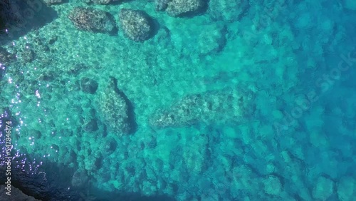 Paradise blue Lagoon turquoise crystal clear water. Tranquil aerial view flight vertical bird's eye view droneof ibiza Aubarca bay at daytime summer 2022. 4k Cinematic photo