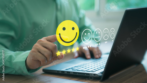 Man hand using computer laptop with popup five star icon for feedback review satisfaction service, testimonial. Customer service experience and business satisfaction survey.