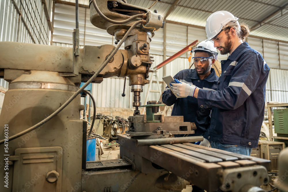 Team of engineers practicing maintenance Taking care and practicing maintenance of old machines in the factory so that they can be used continuously.