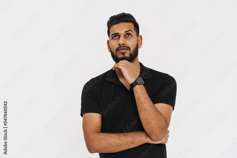 Bearded indian man with smartwatch posing and looking upward