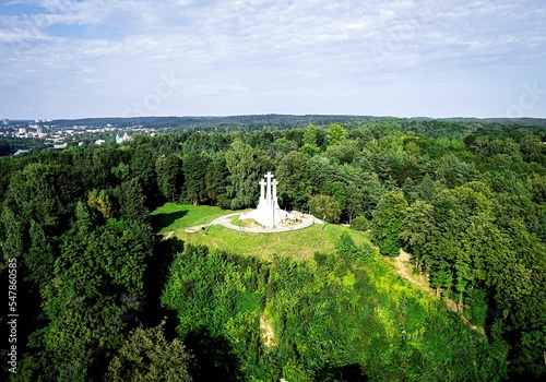 Aerial view of the Three Crosses Monument surrounded by trees under the cloudy sky in Kalnai Park photo