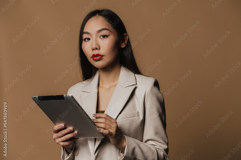 Young asian woman holding tablet computer and looking at camera Young asian woman holding tablet computer and looking at camera