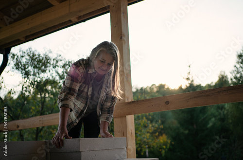 Mature woman working on construction site of their new house. photo