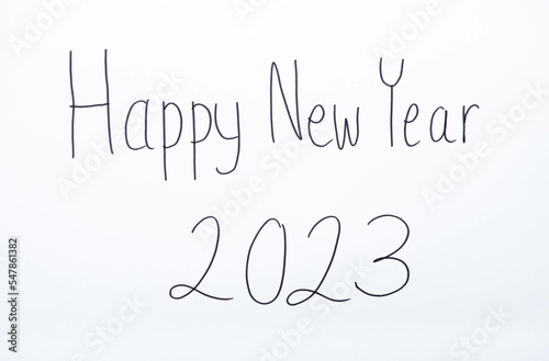 Handmade writing on the white wall, Happy New Year 2023