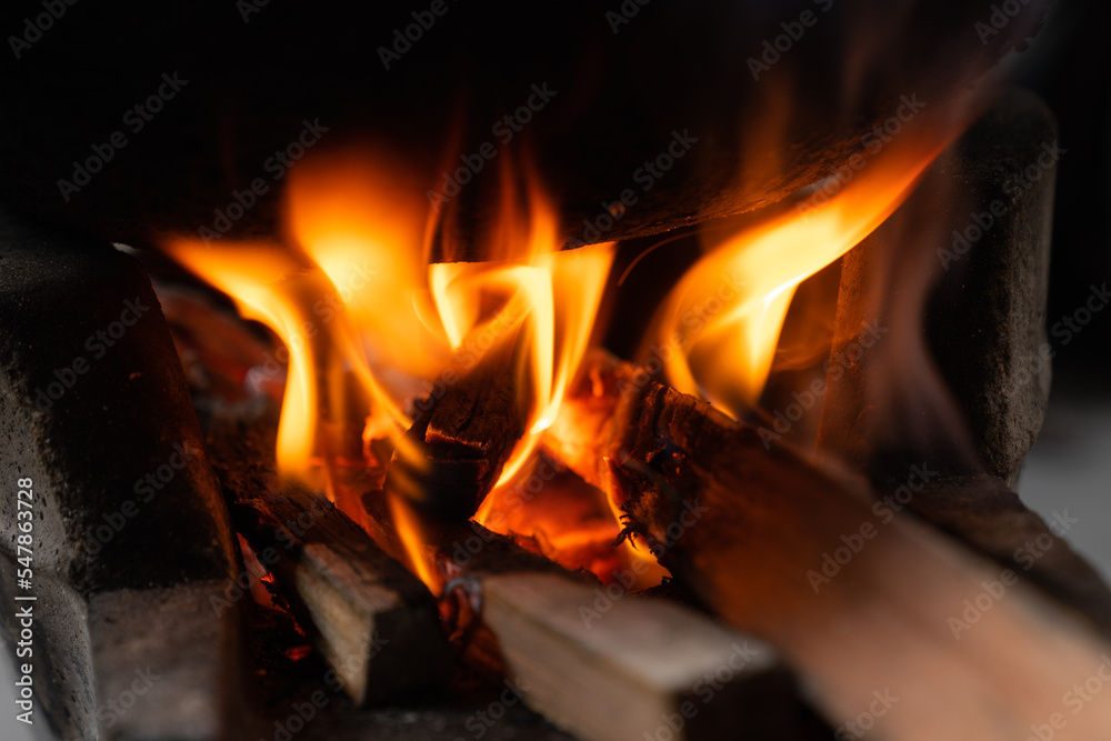 Flames burning high in a charcoal stove,Fire flames background.Add firewood to increase the power of fire.