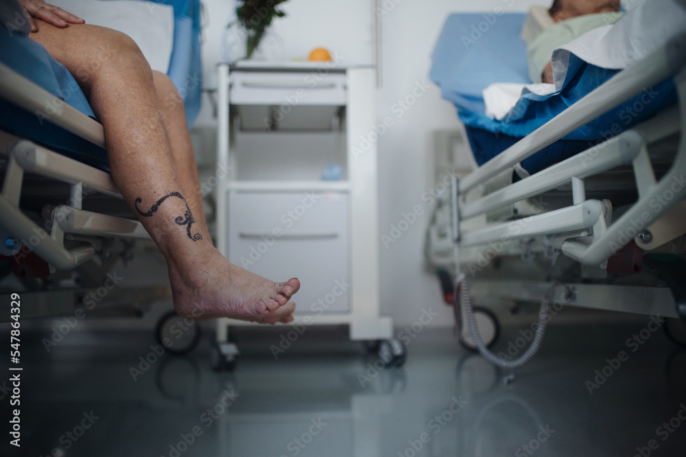 Close-up of womans leg trying to get out of hospital bed. Close-up of womans leg trying to get out of hospital bed.
