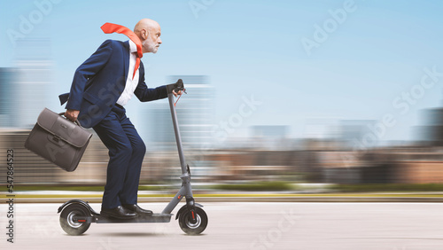 Fotografiet Corporate businessman riding a scooter
