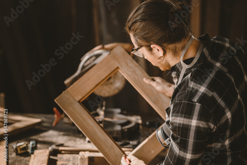carpenter male wood builder worker making wooden furniture job in workshop