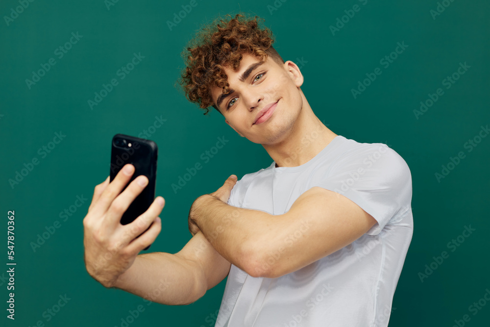 a close horizontal photo of a nice man standing with a smartphone in his hand, hugging himself by the shoulder a close horizontal photo of a nice man standing with a smartphone in his hand, hugging himself by the shoulder