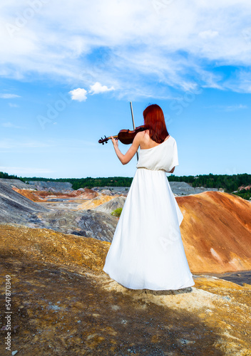 Billede på lærred portrait of a red-haired violinist in full-length rear view with elegant hands p